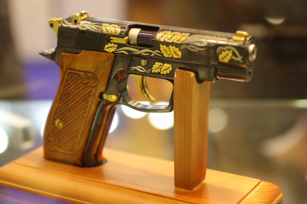 Подарочный пистолет с деревянной резной ручкой и золотой обработкой на выставке «Интерполитекс-2011»